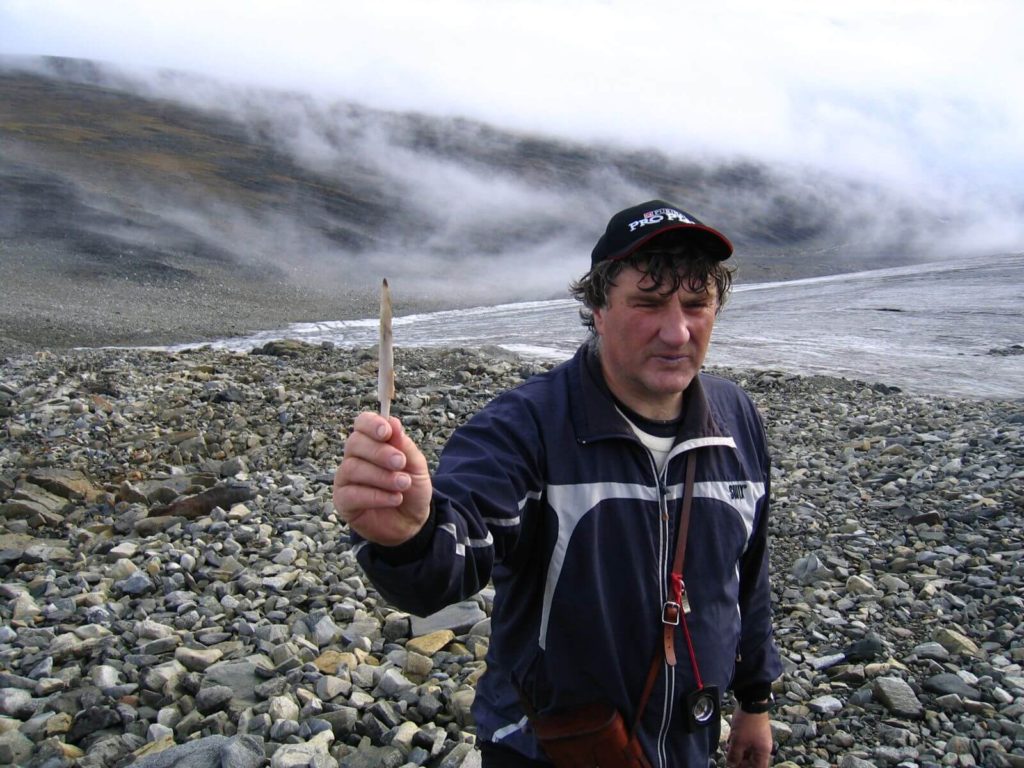 Jan Stokstad holding a bone arrowhead, found during the big melt in 2006.