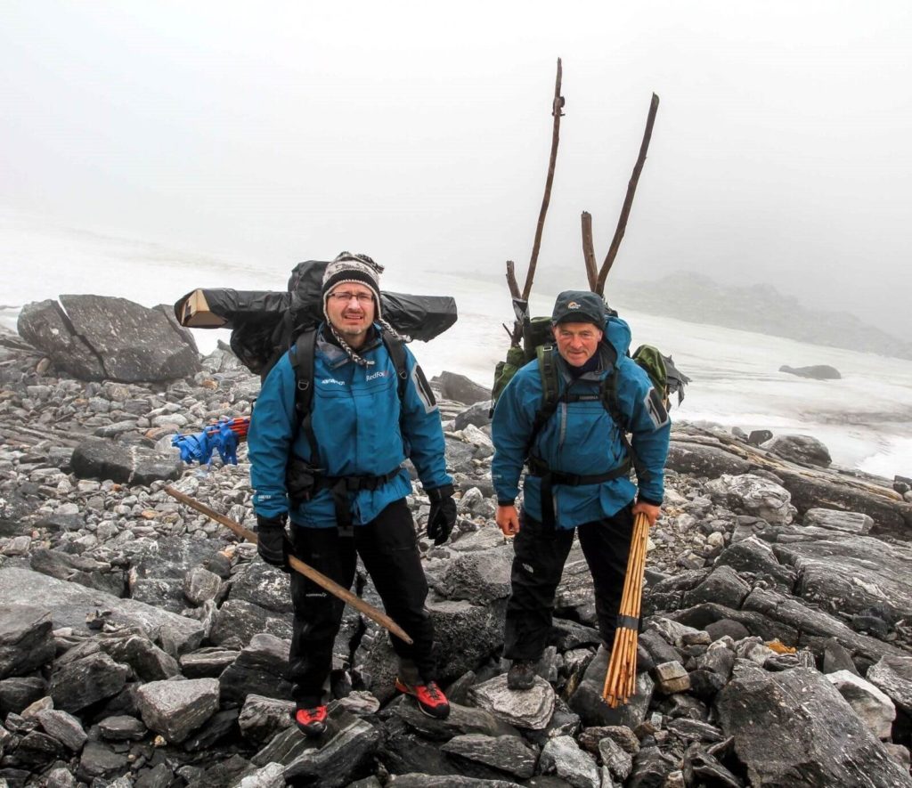 Reidar and Lars in the Lendbreen mountain pass, carrying finds.