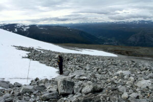 A glacial archaeologist measures the snow line at Åndfonne ice patch